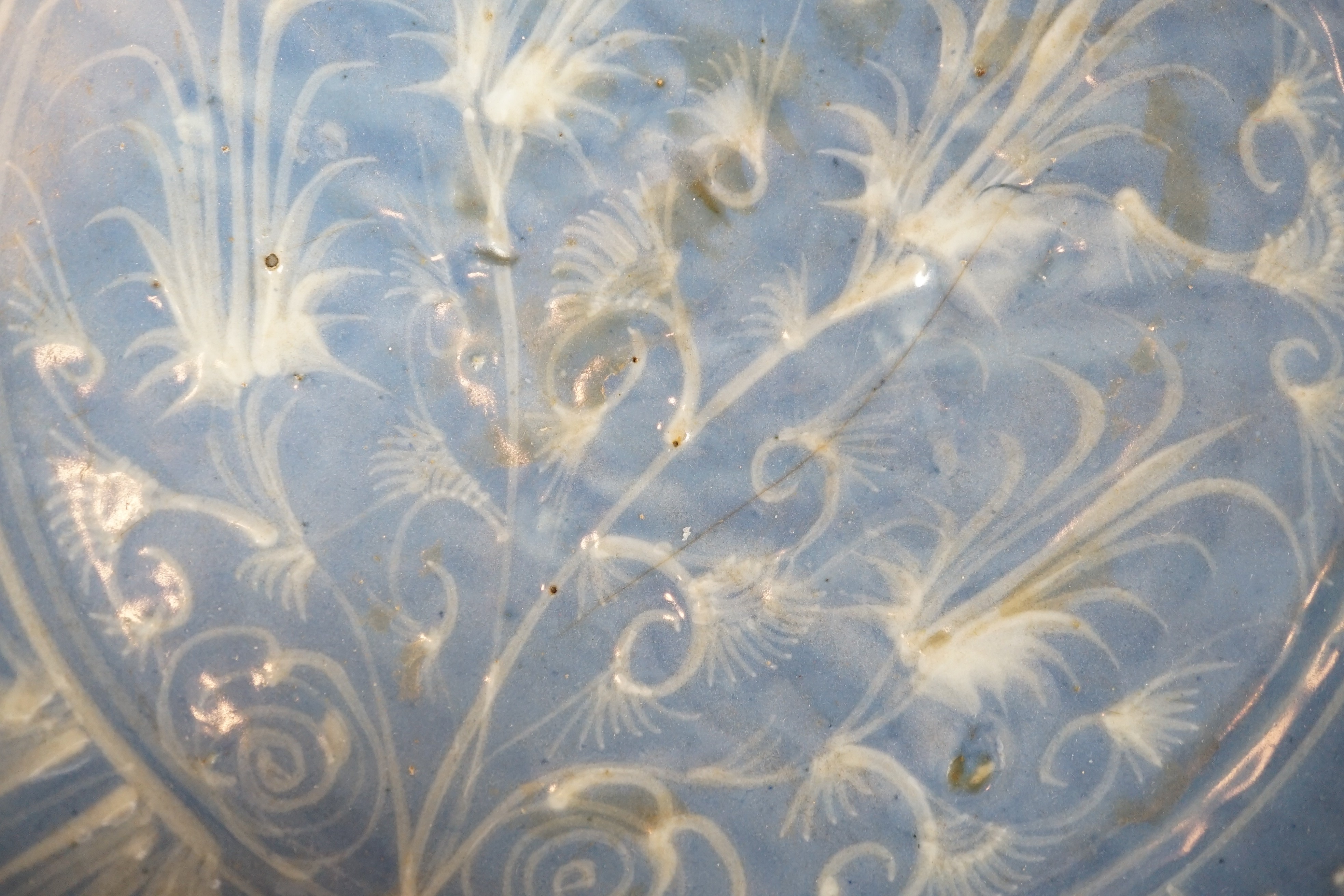 A Chinese Swatow slip-decorated blue glazed deep dish, Zhangzhou kilns, early 17th century, 38cm wide, crack to base